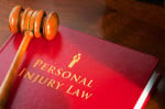 Gavel resting on a red book titled "Personal Injury Law," symbolizing legal action and justice.