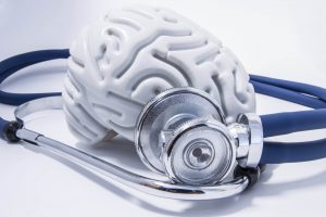 Silver image of a brain with stethoscope next to it