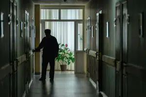 Silhouette of nursing home patient walking down a hallway
