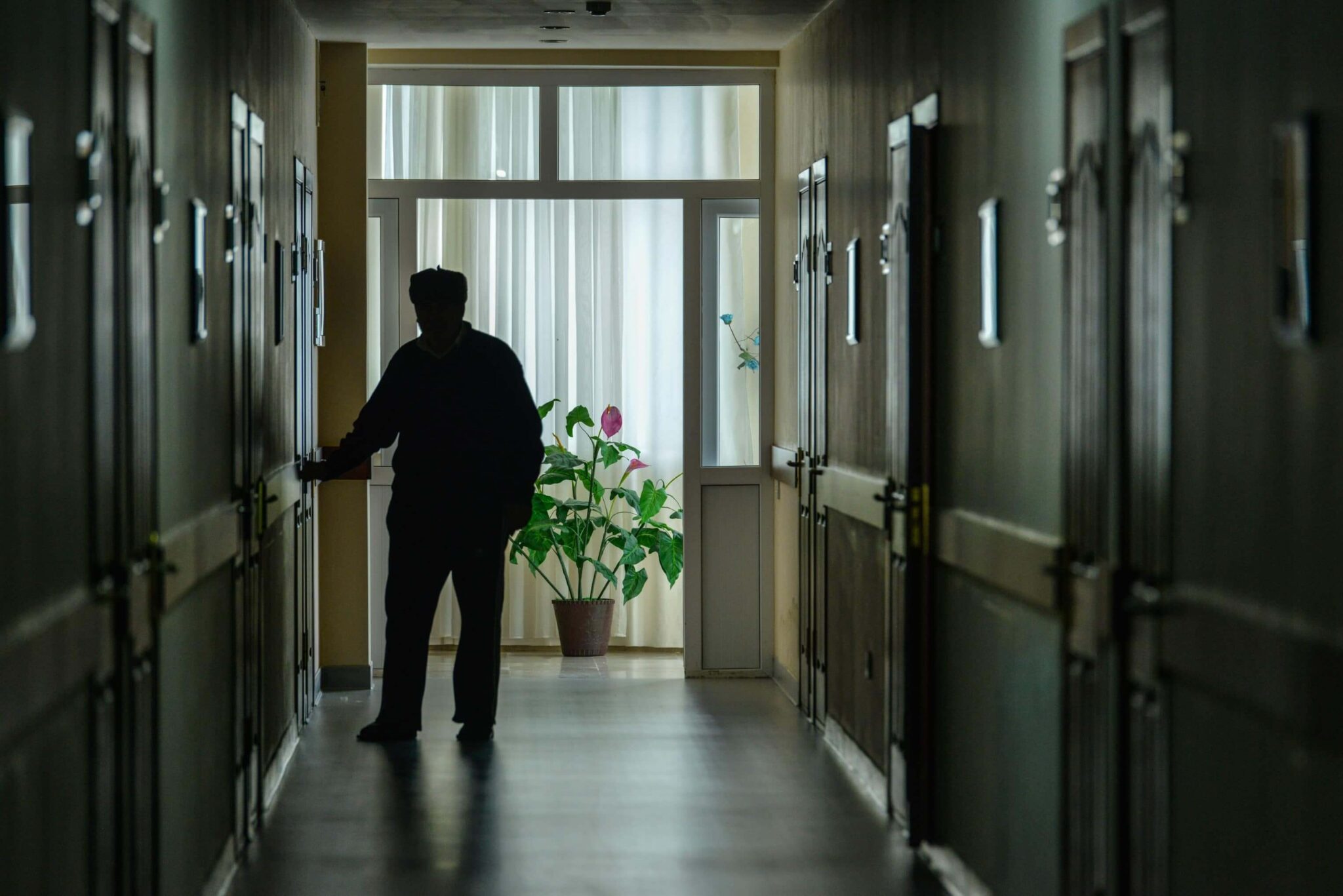 Silhouette of nursing home patient walking down a hallway