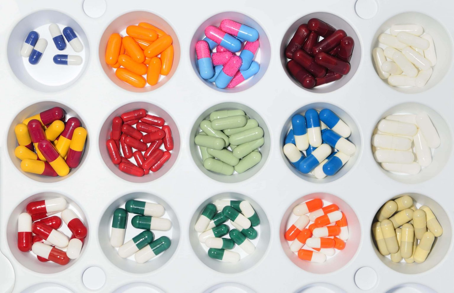 variety of pills displayed in round containers.
