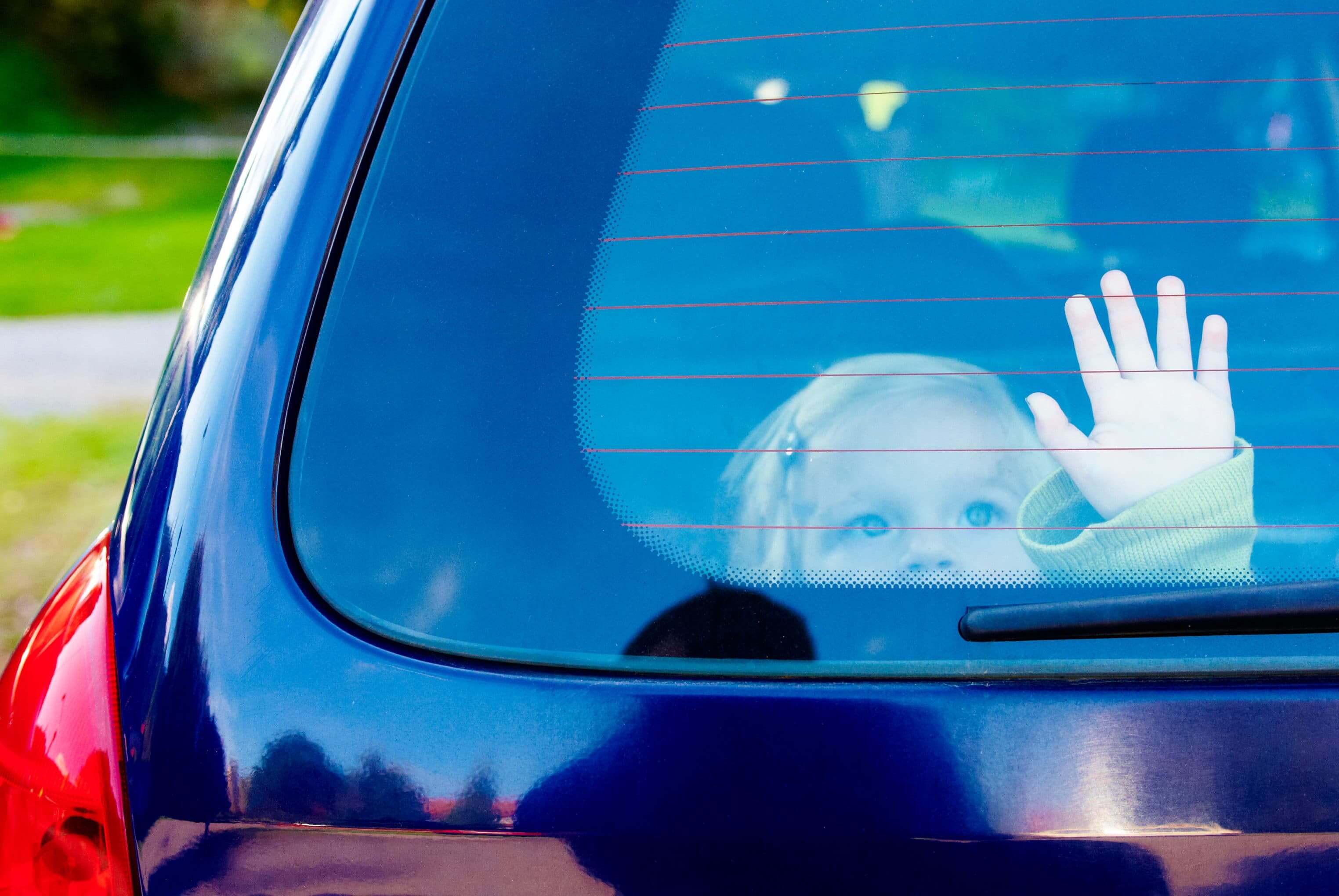 child looking out through rear window in car