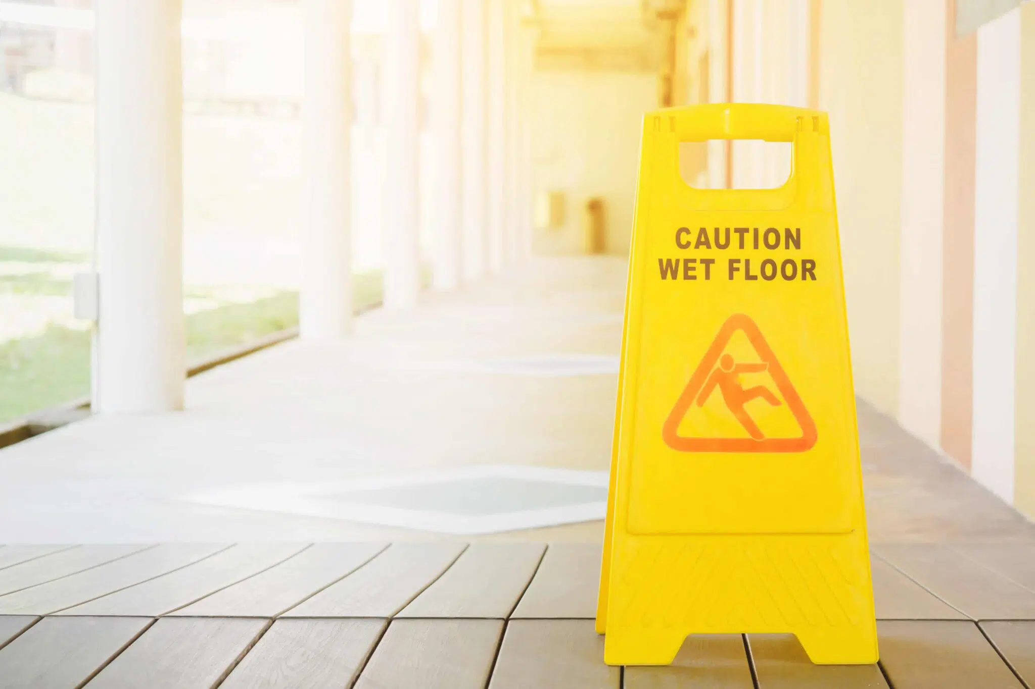 Caution Wet Floor sign on porch setting with bright sunny background