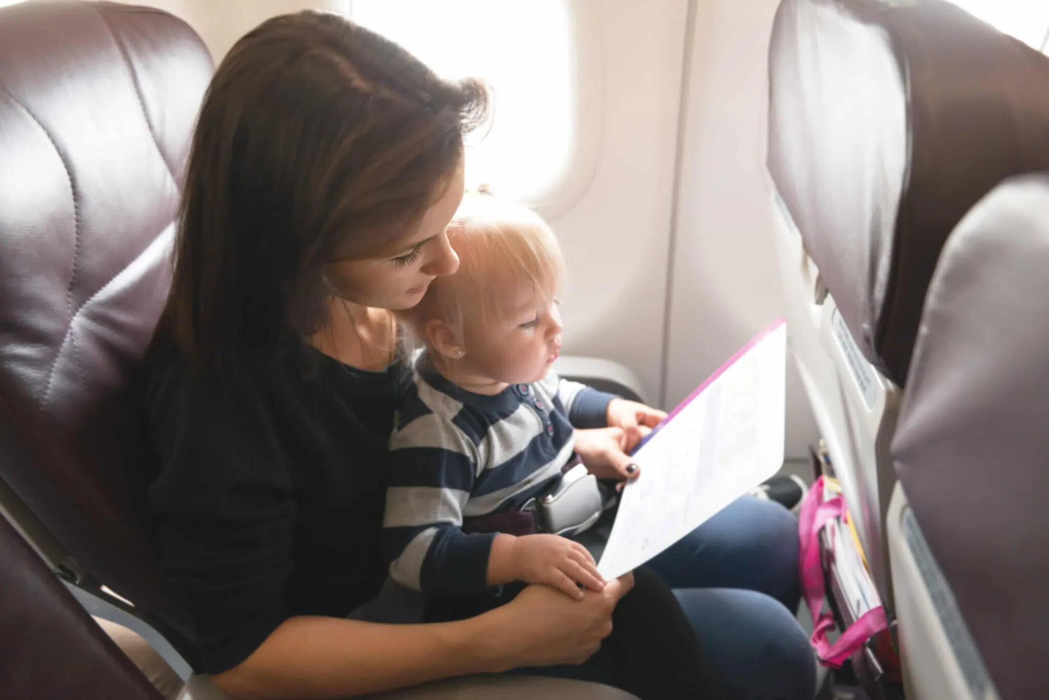 Woman reading to a child on an airplane