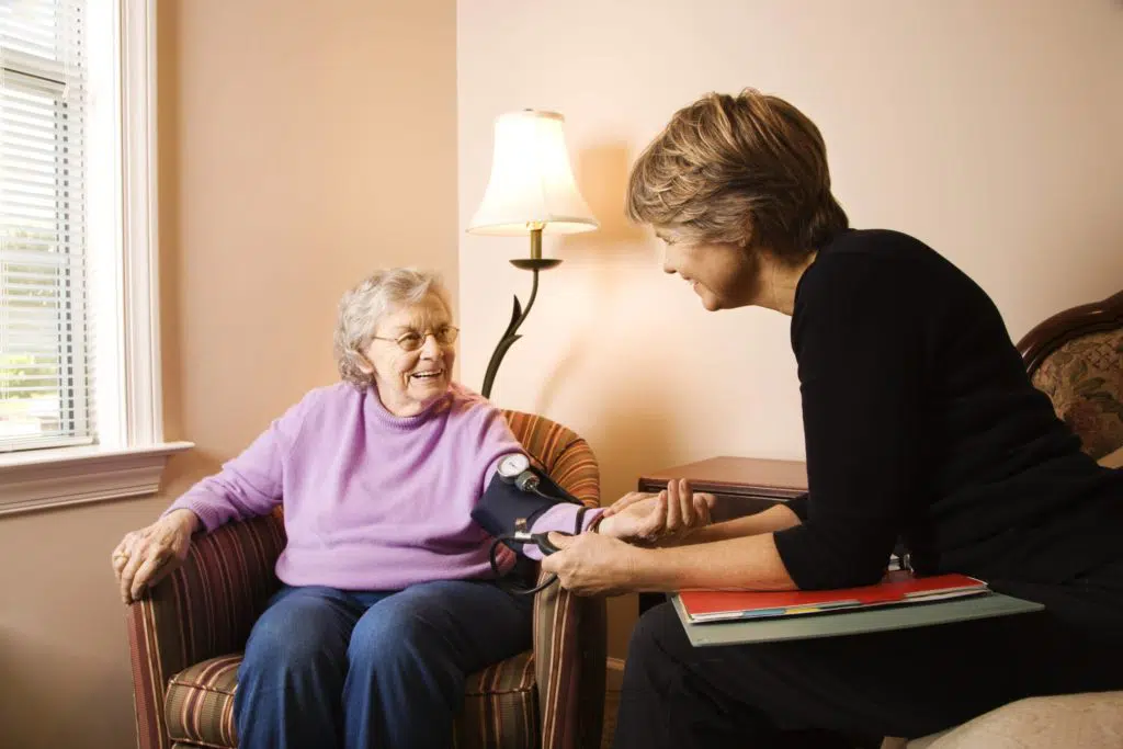Nursing home caretaker taking the blood pressure of a senior patient