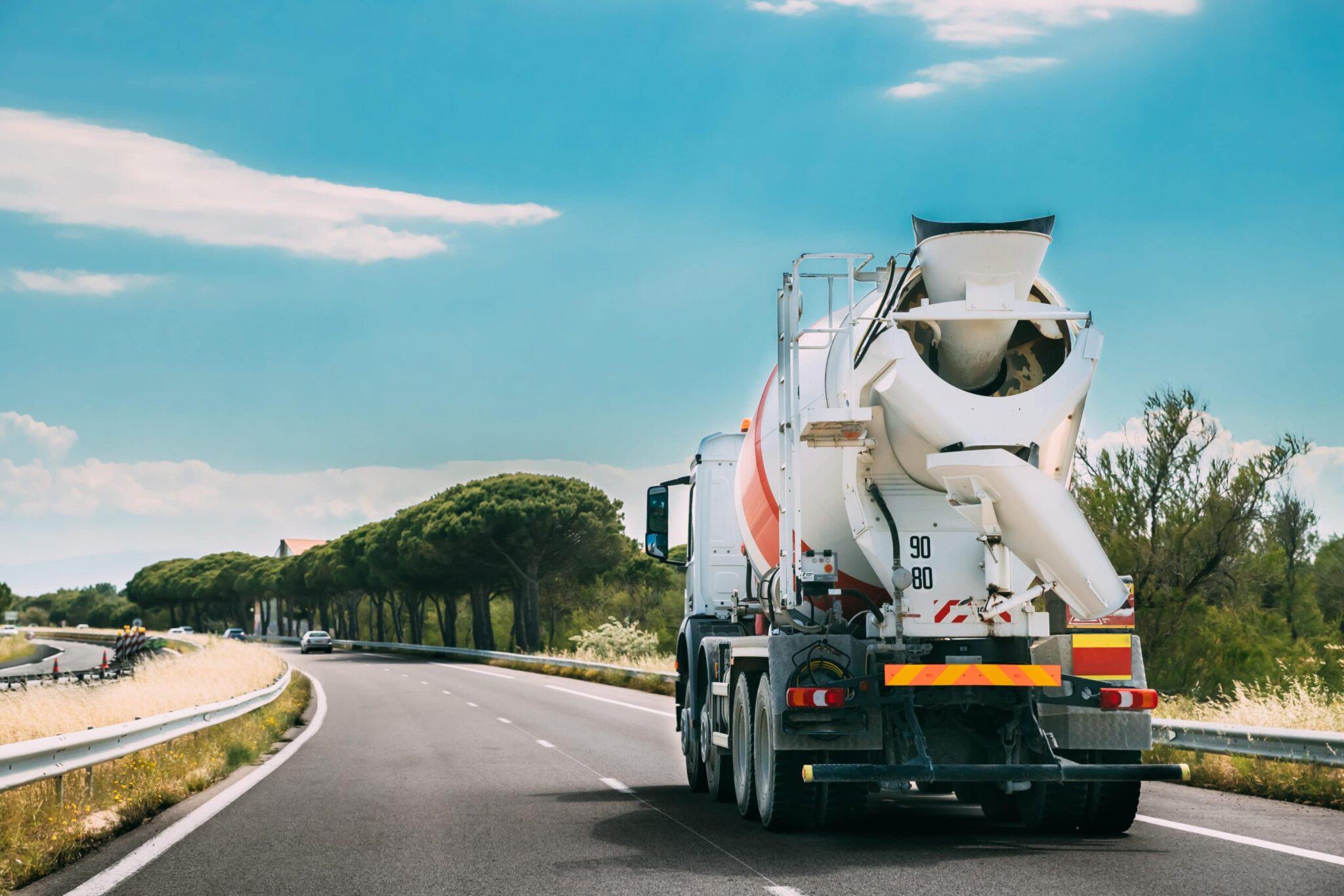 MIxer truck driving on an open road with a blue sky