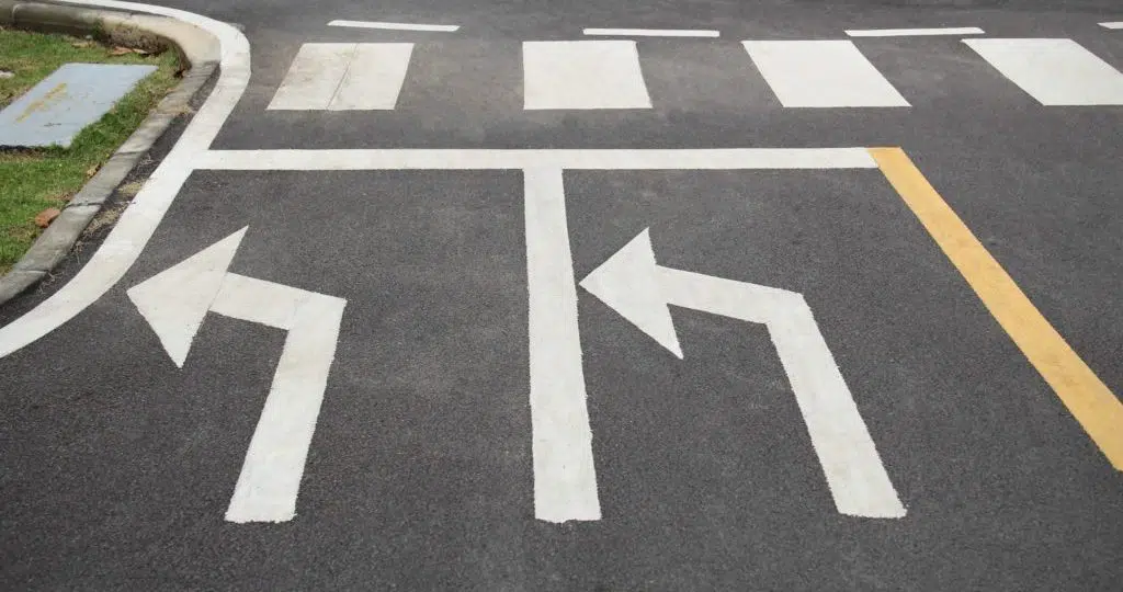 Left-turn signals drawn at an intersection in white paint