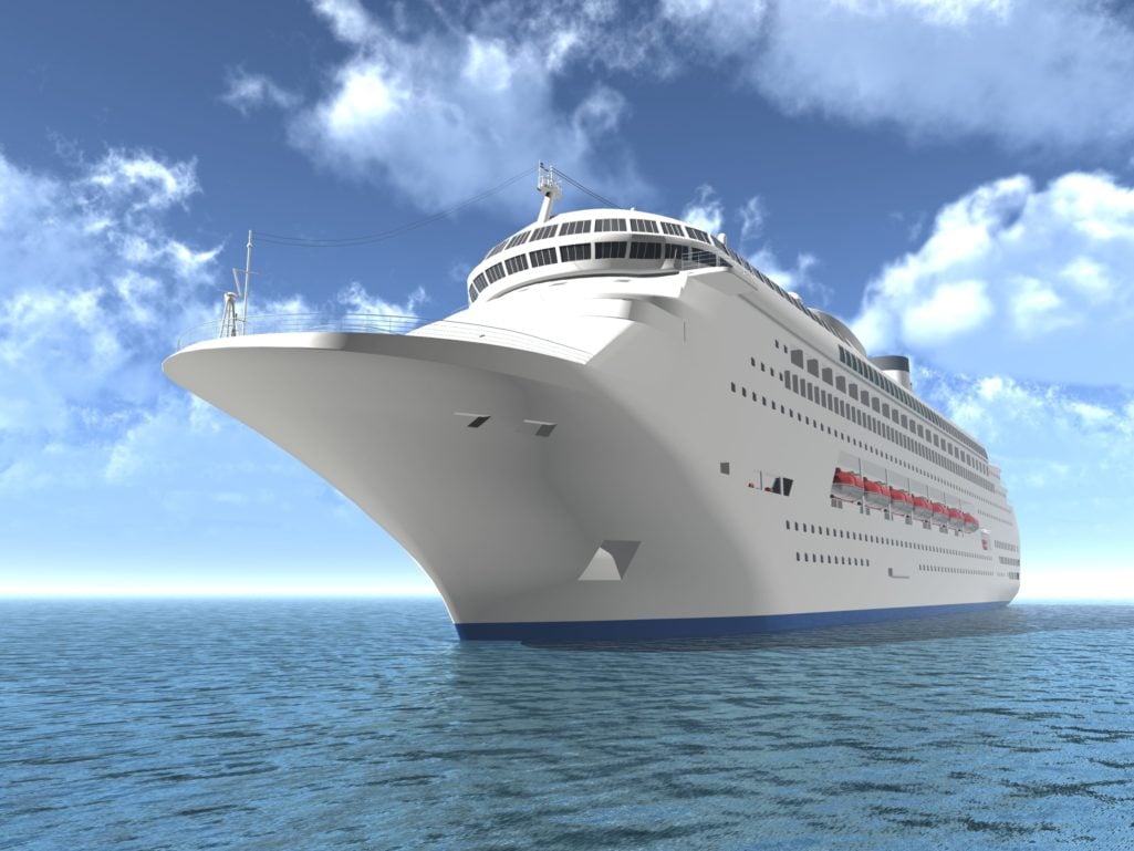 Cruise ship on the ocean with blue sky and clouds in the background