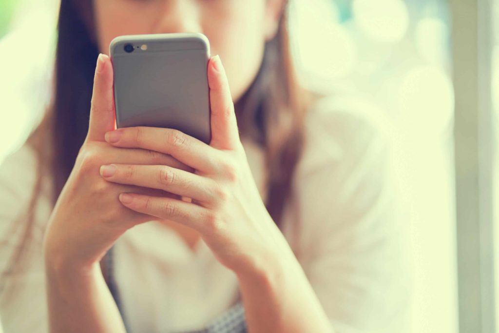 A woman focuses on her phone.