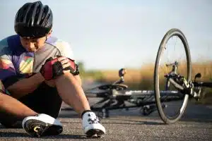 Cyclist falls off road bike, injuring knee. Bicycle accident causing injuries.
