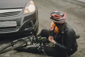 Female in black jacket involved in car crash, needing assistance.