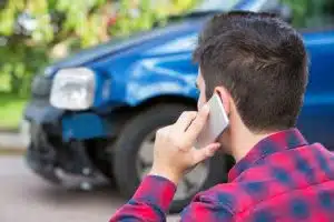 Man reporting car accident via mobile phone.