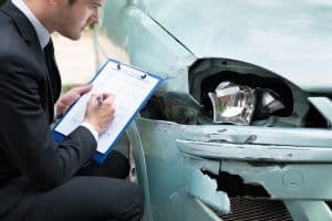 Side angle of insurance agent's clipboard notes during examination of truck and car post-accident.