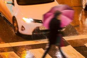 Pedestrians in dangerous situation in a crosswalk in the city street at night.