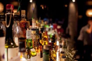 Various bottles of spirits and liquor lined up on a bar shelf