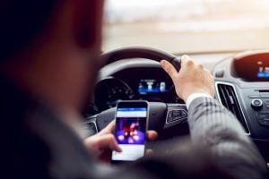 Man using mobile phone while driving a car. Concept of distracted driving.