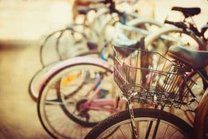 A row of parked bicycles with a focus on one with a basket.