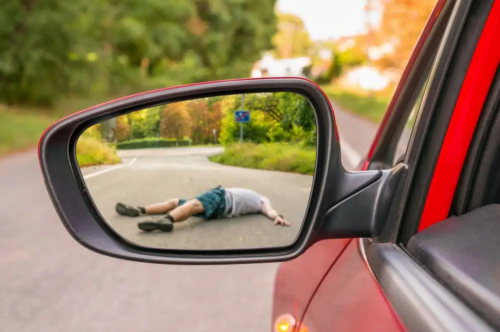 Rearview mirror reflecting a man hit by a car - hit and run scene