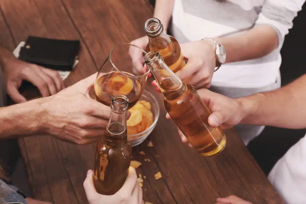 Close-up view of friends enjoying alcoholic drinks at a bar