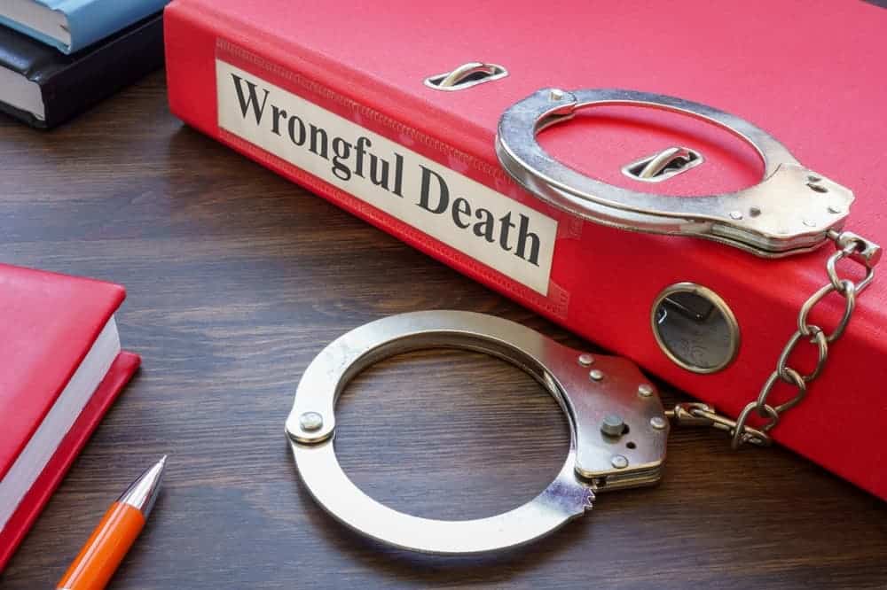 Folder about wrongful death and handcuffs.