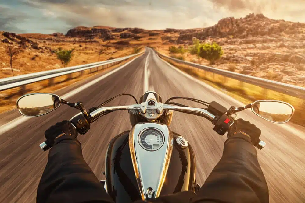 Driver riding motorcycle on an empty asphalt road