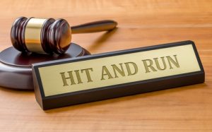 Gavel next to a nameplate engraved with the words “Hit and Run” symbolizing legal action after a traffic accident.