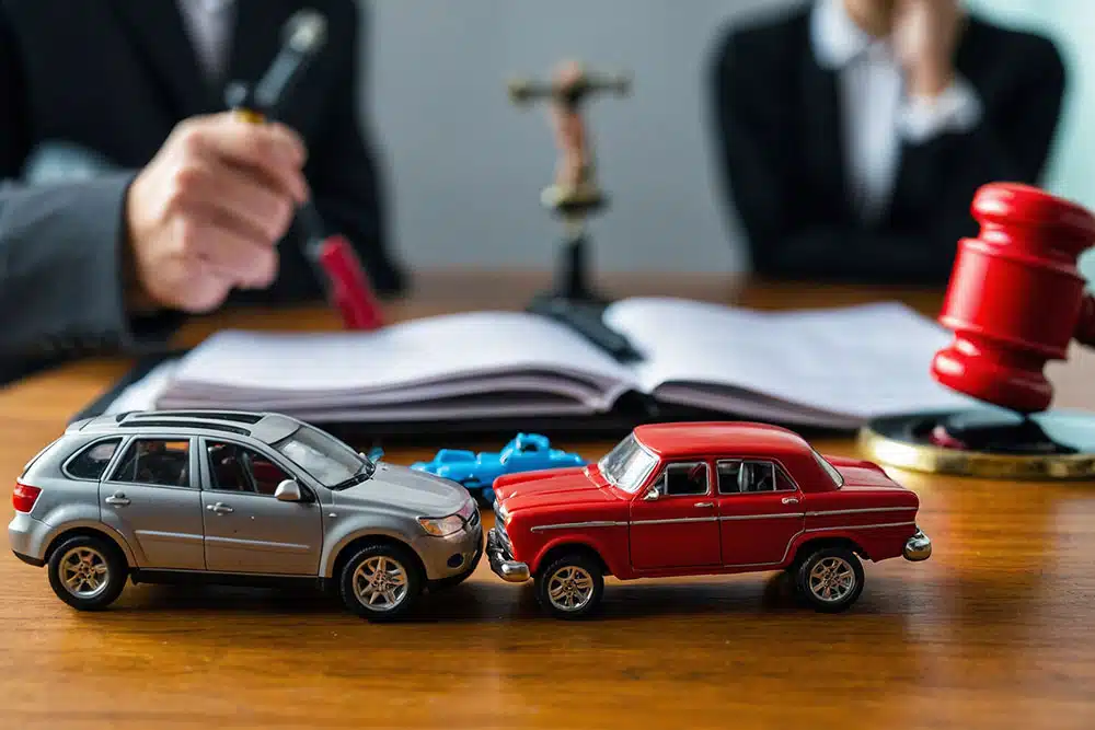 Small car model and judge’s gavel on a table, symbolizing Pennsylvania car accident lawsuits and the statute of limitations deadline.