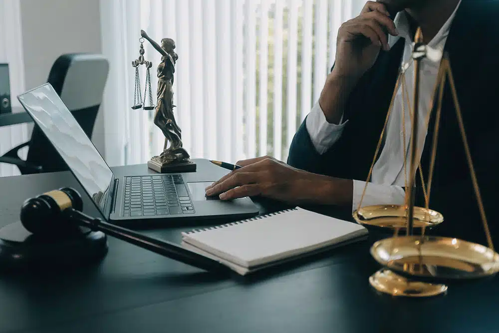 Judge’s gavel on a desk with lawyers meeting in the background, representing legal help after a Lyft accident near Philadelphia International Airport.