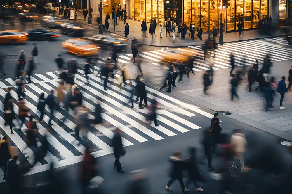 Overhead view of pedestrians walking through a busy city crosswalk, illustrating right-of-way rules for pedestrians in Manhattan crosswalk accident cases.