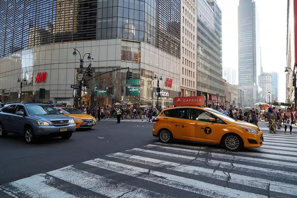 Crowds of pedestrians crossing the street in Times Square in New York City, illustrating busy Manhattan crosswalks where right-of-way rules are critical.