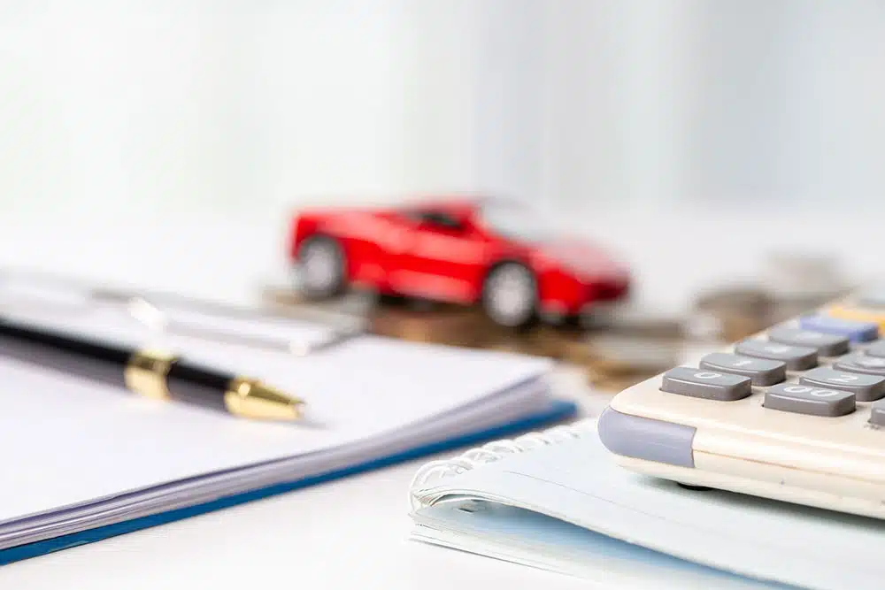 Toy car next to stacks of coins, representing the medical expense and wage loss limits covered by New York’s no-fault insurance after minor accidents.