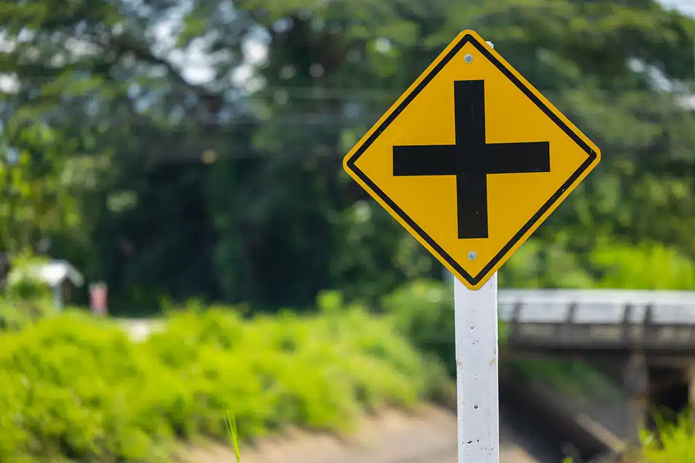 Yellow intersection warning sign on the roadside, symbolizing high-risk crossroads and dangerous intersections for drivers in Philadelphia.