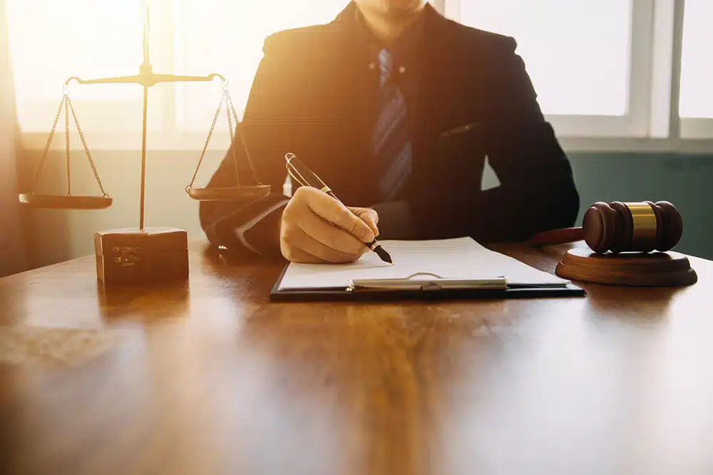Client consulting with a lawyer across a desk, representing the importance of getting legal advice before speaking to the insurance company after a crash.